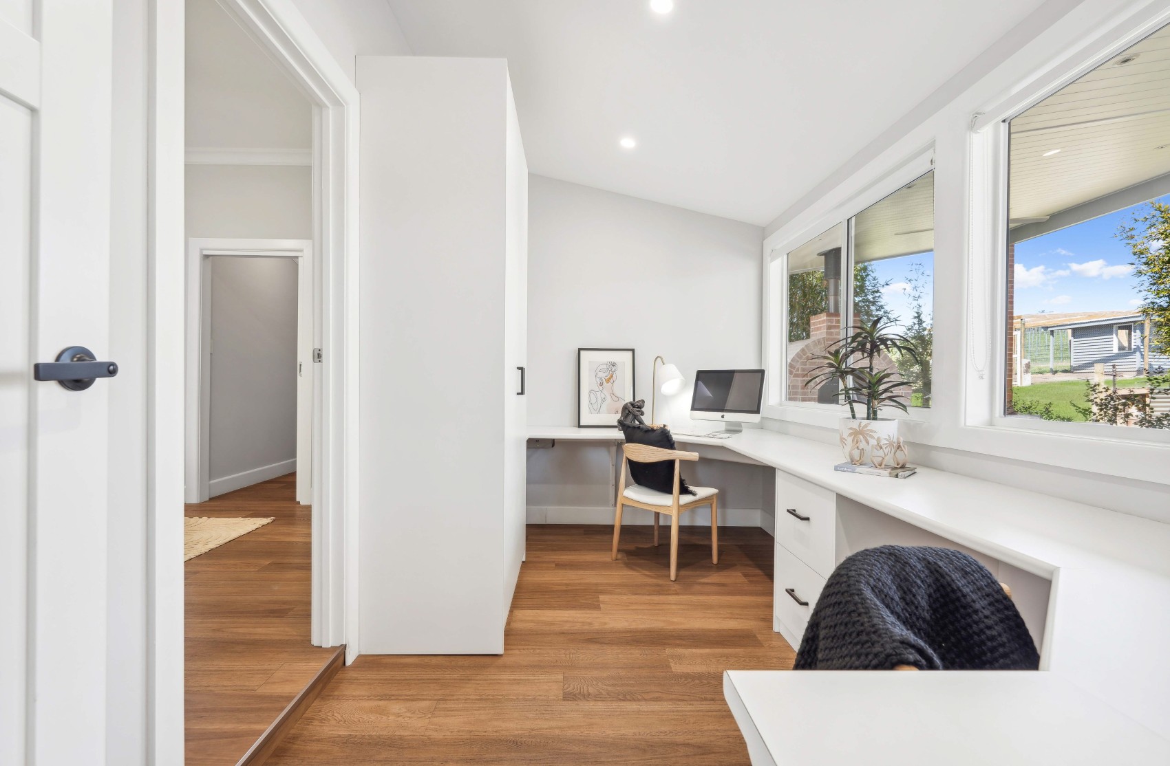 Built-in corner desk in the Charleston home office nook, windows to the back garden