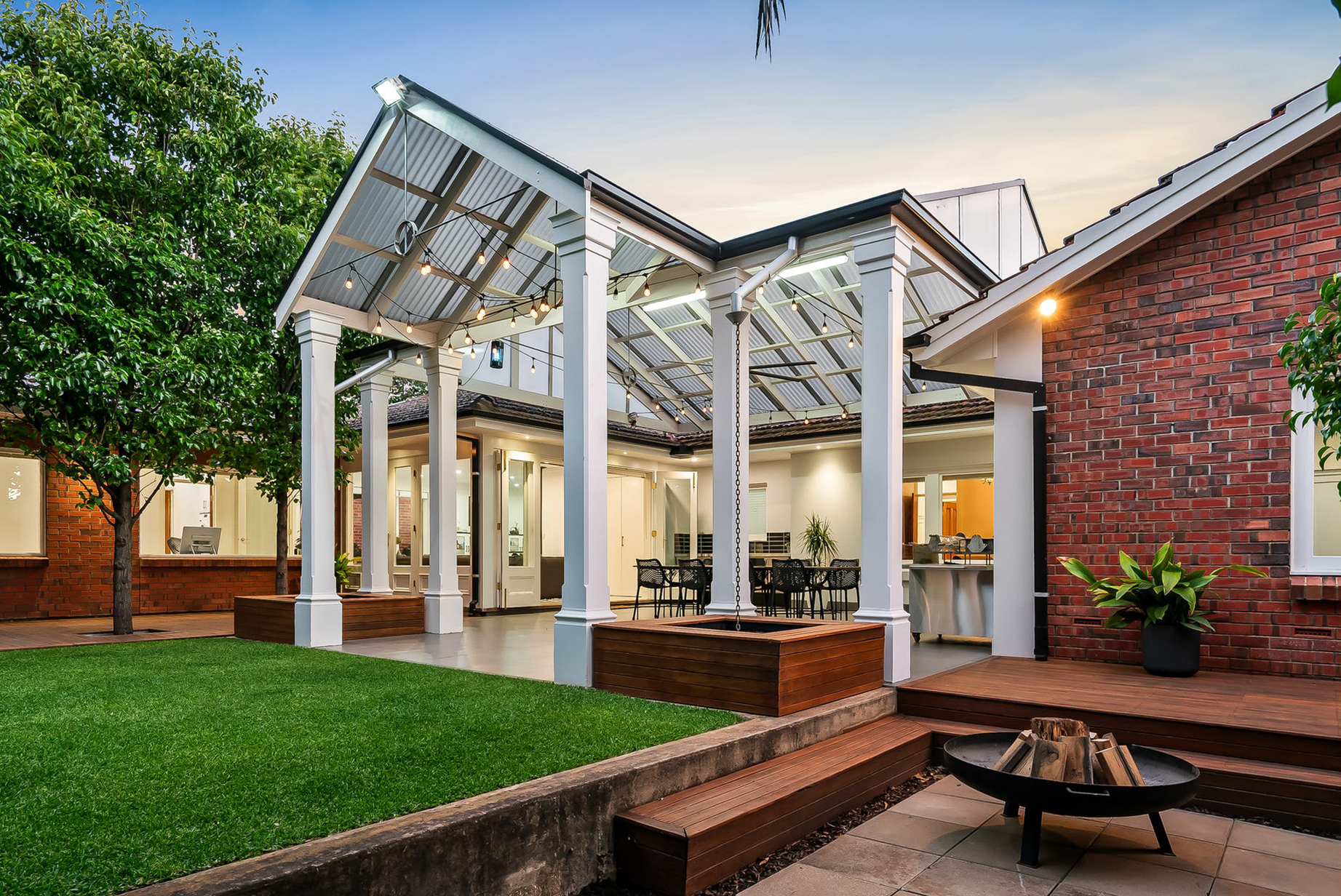 Twin gables of the Burnside pavilion over the new deck, with the fire pit terrace in the foreground
