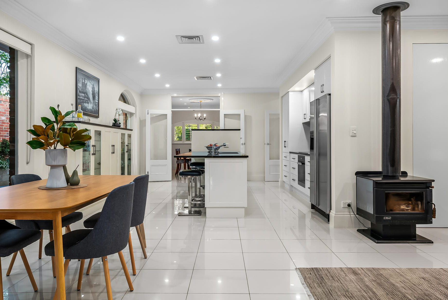 Open-plan dining and the new island bench at Burnside, with the freestanding wood heater