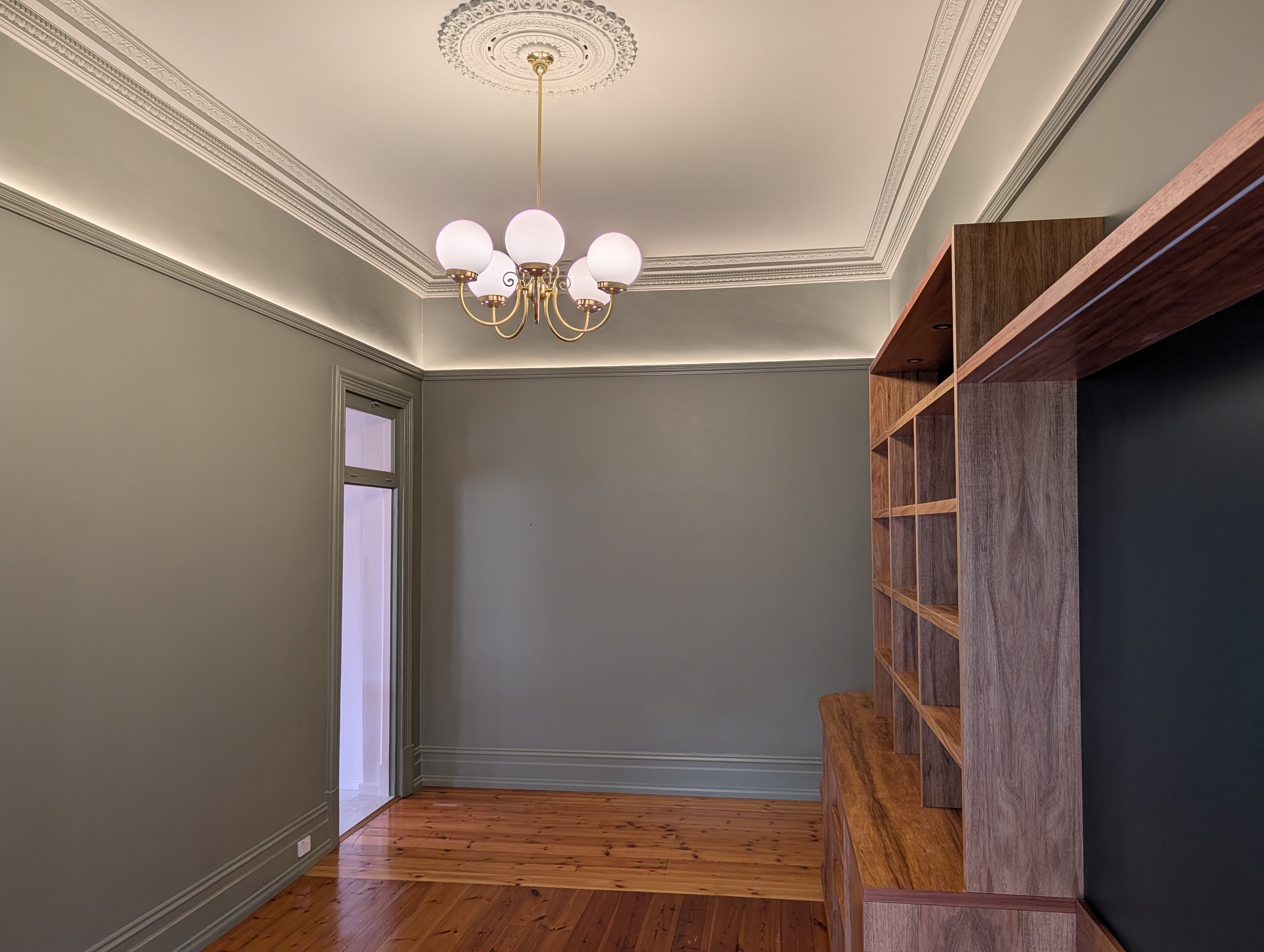 Green living room with concealed LED lighting above the picture rail, a ceiling rose and a brass chandelier