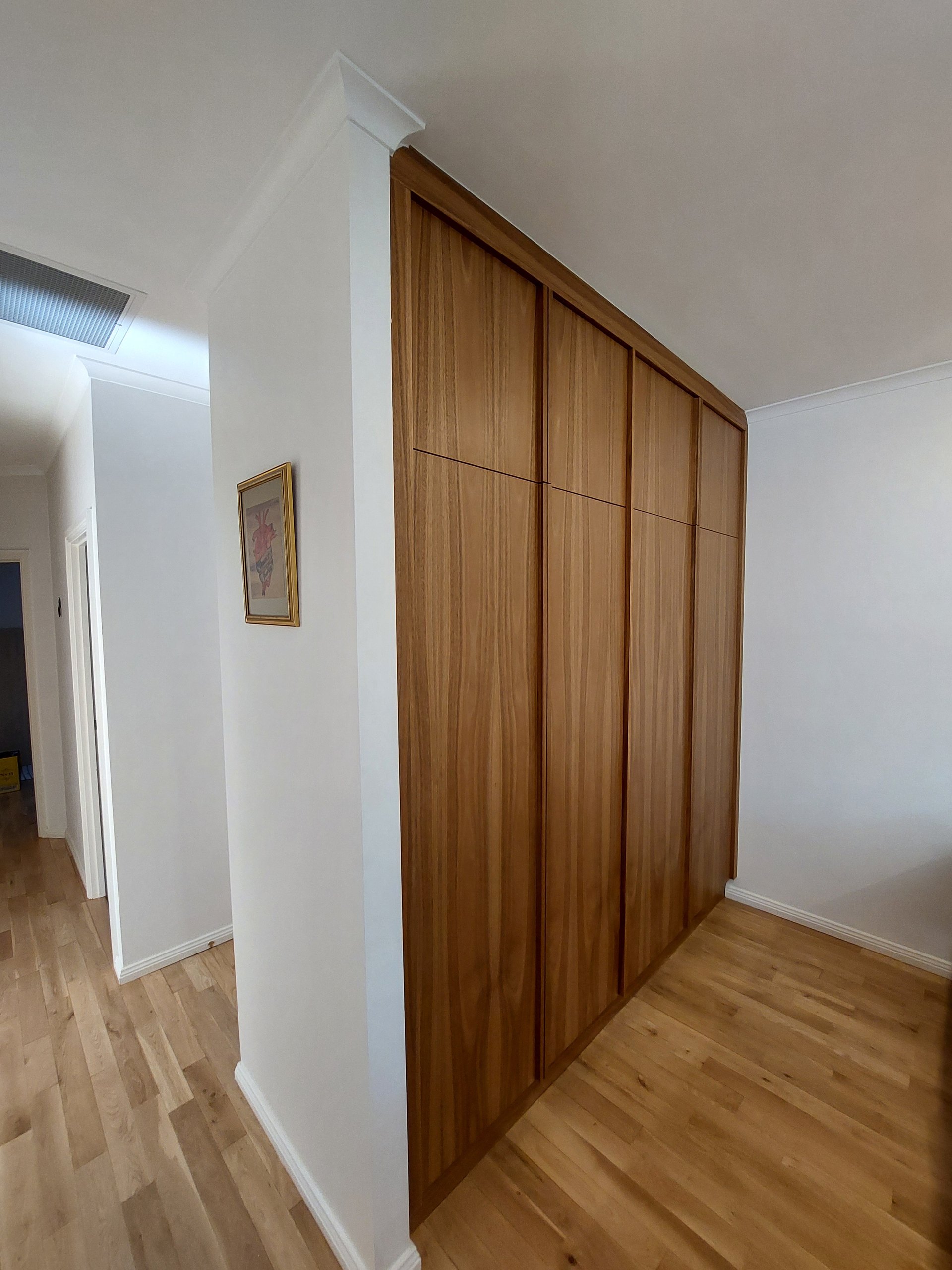 Hallway with polished hardwood floors and the timber laundry doors on the right