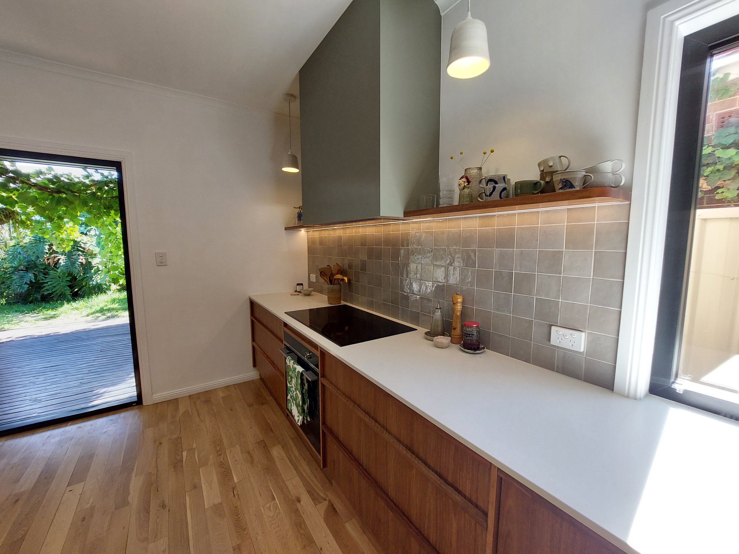 Kitchen seen from the new double-glazed sliding door, along the benchtop to the window