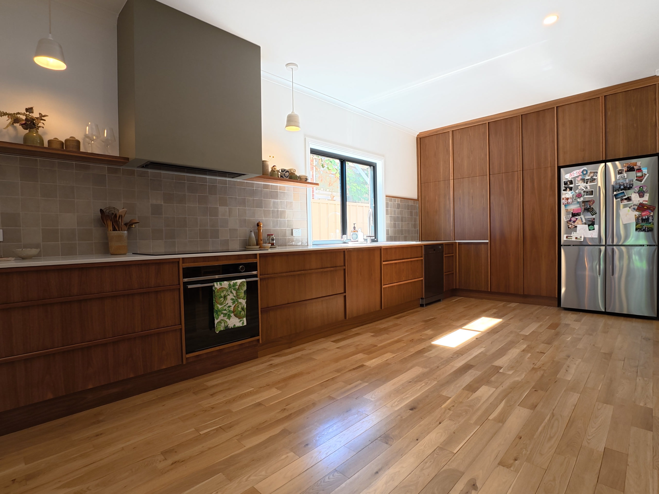 Timber kitchen with the bench run, oven, pantry wall and fridge