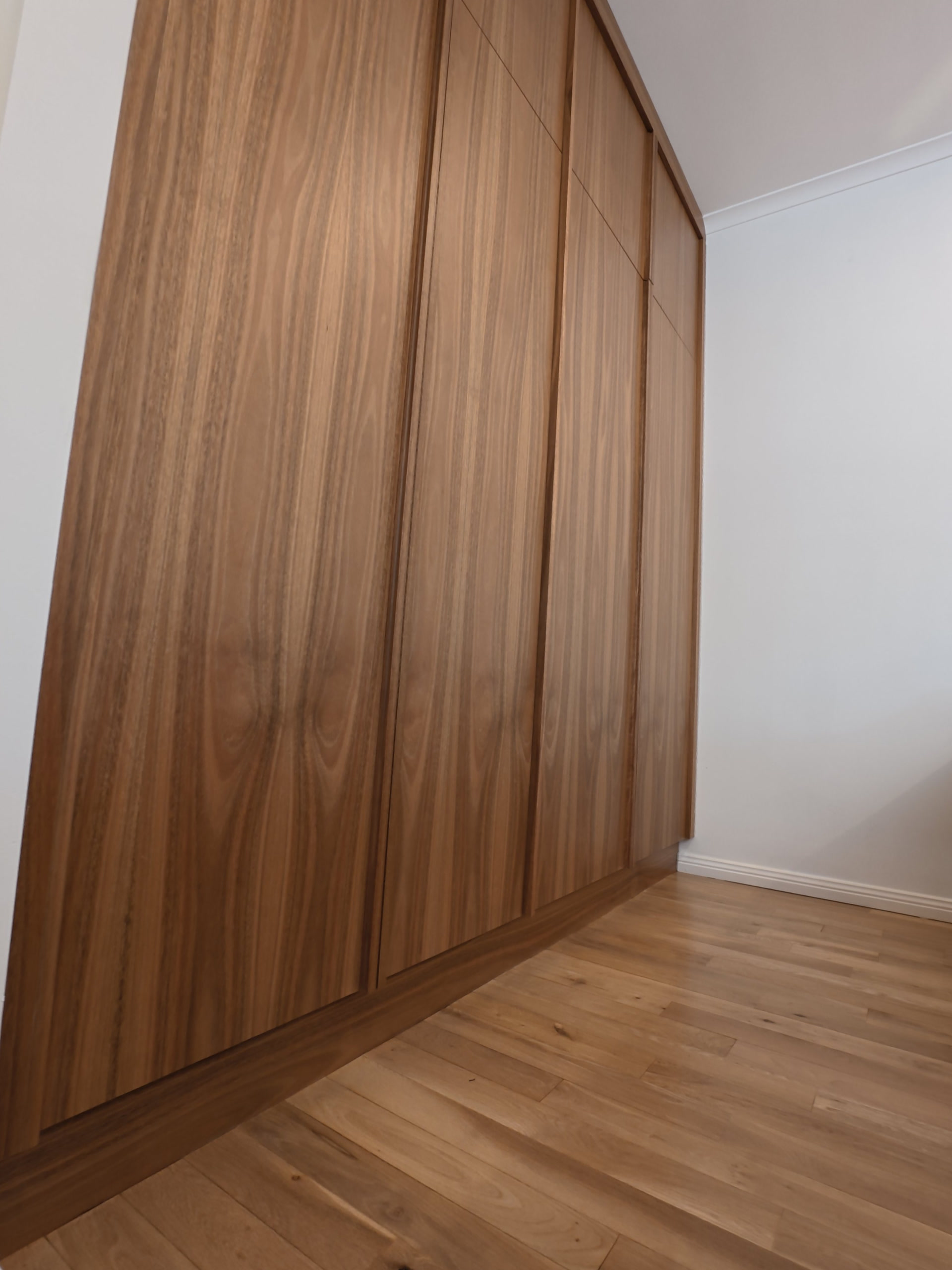 Timber laundry doors seen at an angle along the hallway